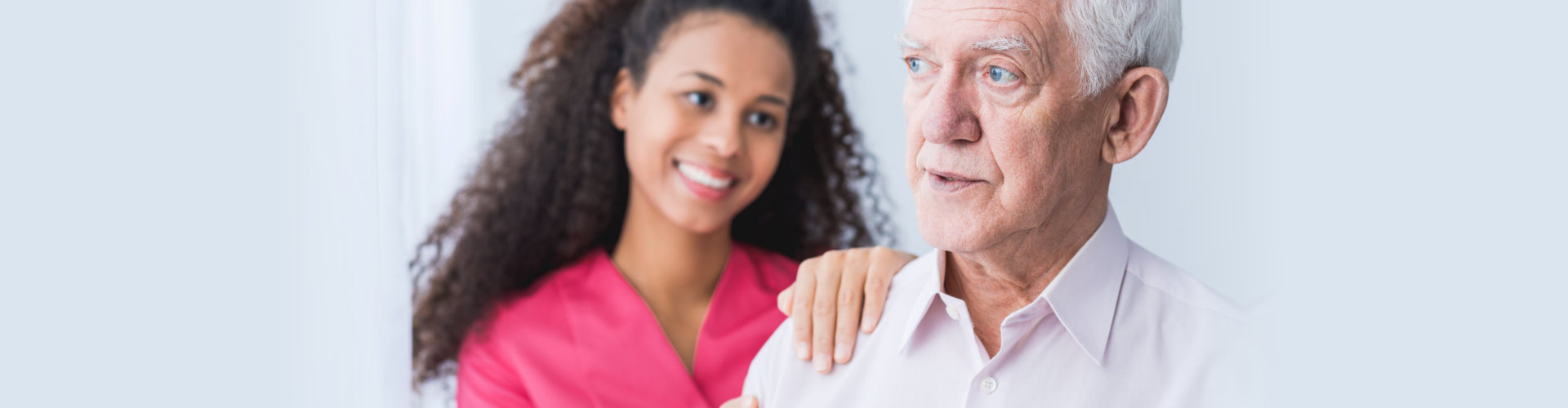 Female carer assisting and supporting senior man